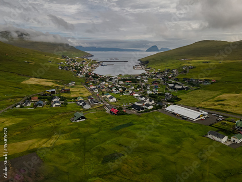 Beautiful aerial view of the town of Miovagur in the Faroe Islands, with its :churchs, grass roofs and colorful Houses in front of the ocean 