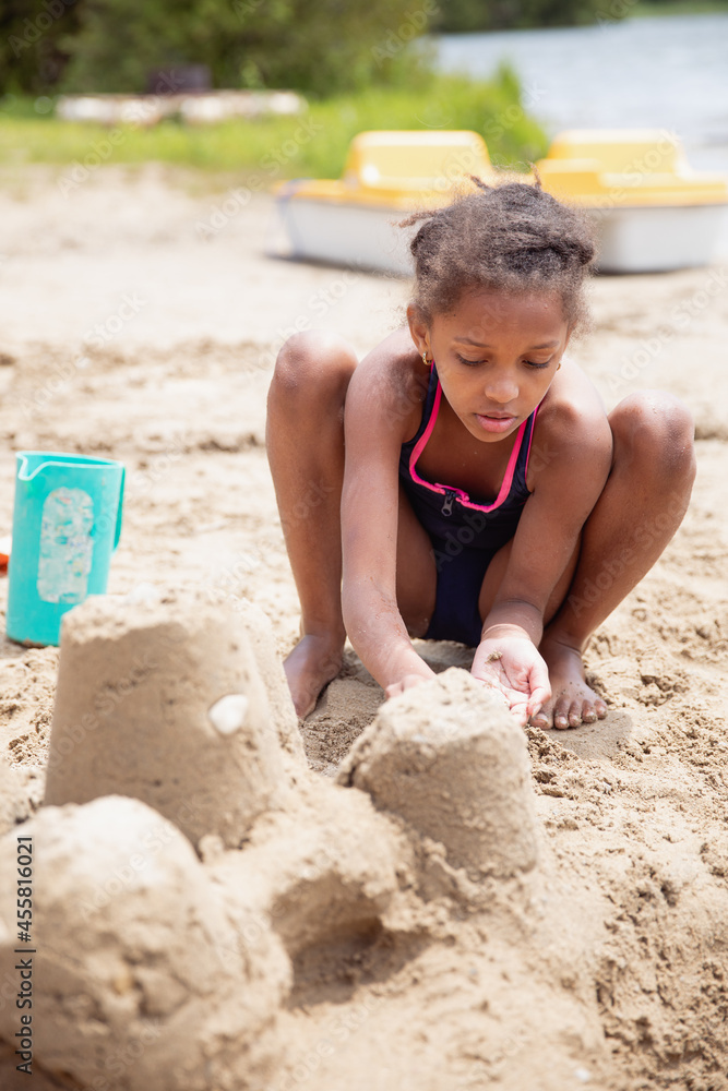 Child playing on a sandy beach while at a lake Child playing on a sandy beach while at a lake