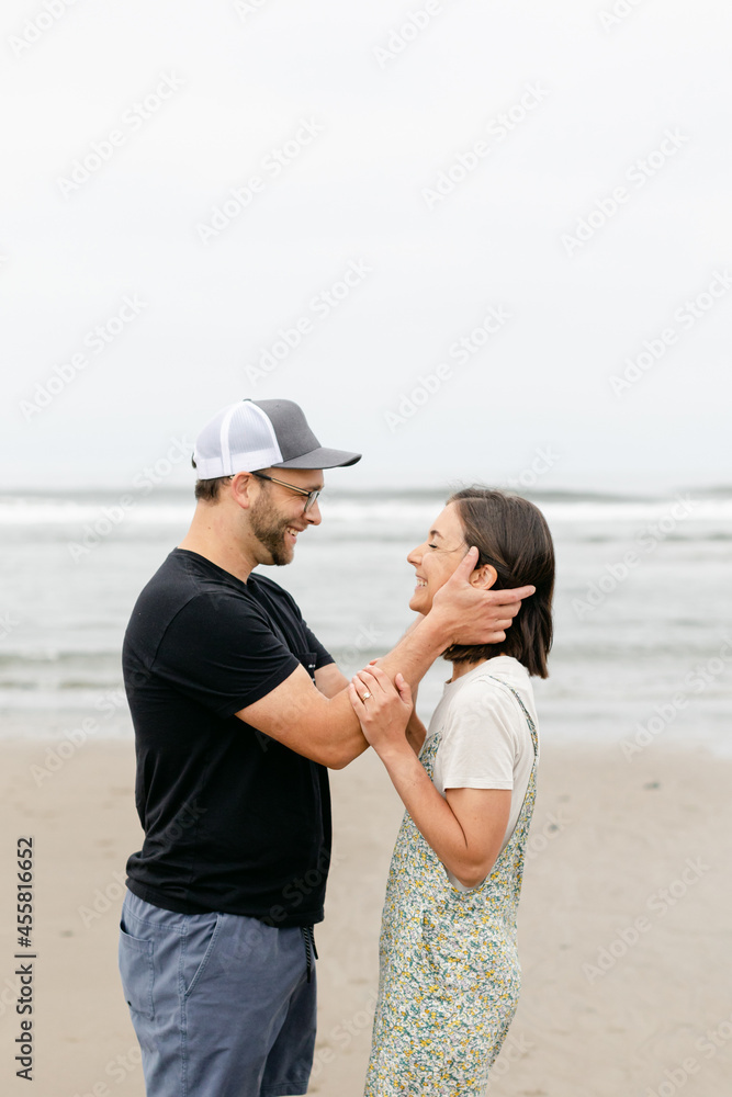 A Husband Holds His Wife's Face in his Hands and Smiles A Husband Holds His Wife's Face in his Hands and Smiles