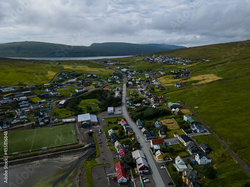 Beautiful aerial view of the town of Miovagur in the Faroe Islands, with its :churchs, grass roofs and colorful Houses in front of the ocean 