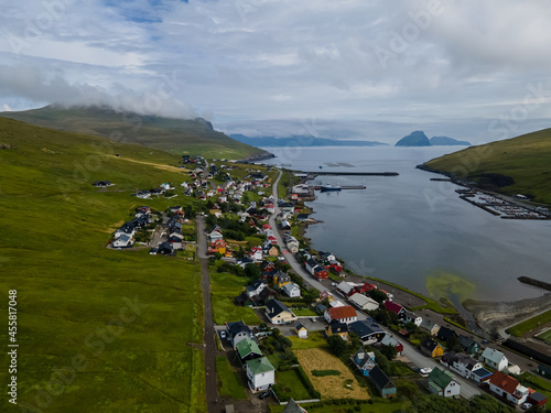 Beautiful aerial view of the town of Miovagur in the Faroe Islands, with its :churchs, grass roofs and colorful Houses in front of the ocean 