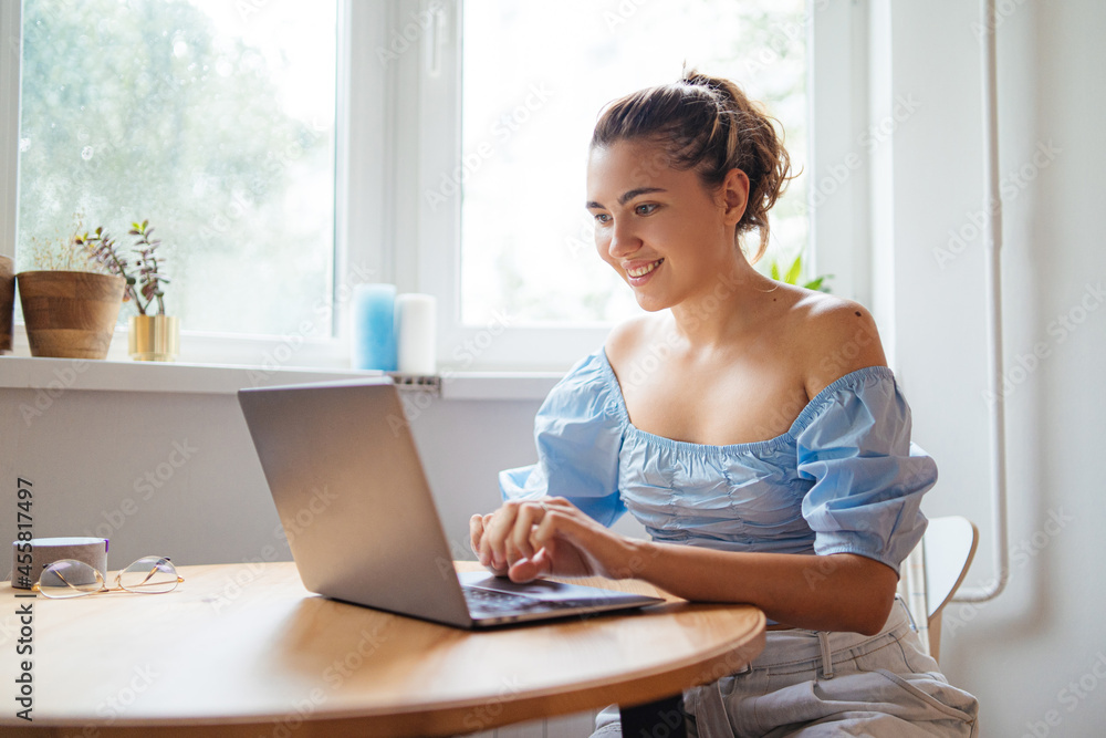 Cheerful female blogger working on laptop Cheerful female blogger working on laptop