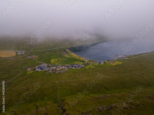 Beautiful aerial view of the town of Miovagur in the Faroe Islands, with its :churchs, grass roofs and colorful Houses in front of the ocean 