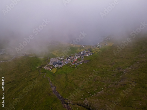 Beautiful aerial view of the town of Miovagur in the Faroe Islands, with its :churchs, grass roofs and colorful Houses in front of the ocean 