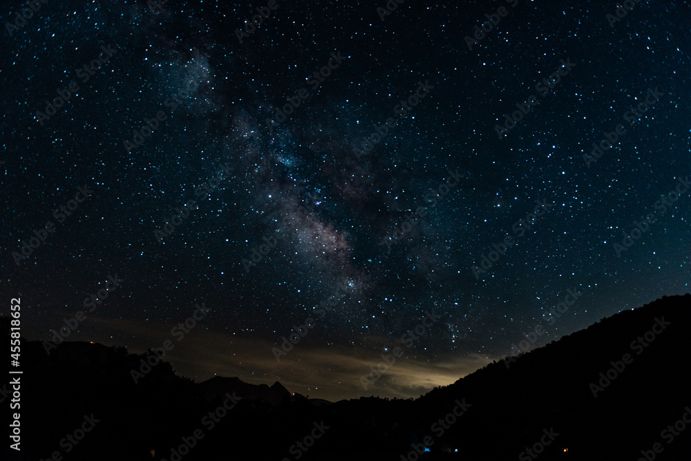 the milky way galaxy as seen through mountains 