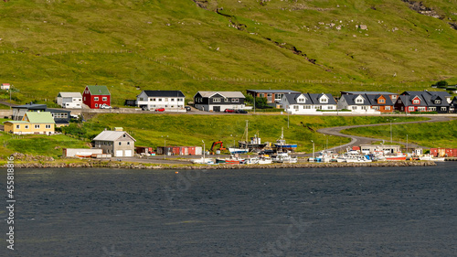 Beautiful aerial view of the town of Miovagur in the Faroe Islands, with its :churchs, grass roofs and colorful Houses in front of the ocean 