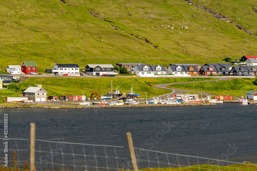 Beautiful aerial view of the town of Miovagur in the Faroe Islands, with its :churchs, grass roofs and colorful Houses in front of the ocean 