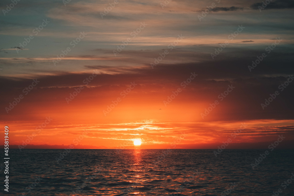 Sol y nubes en el amanecer al lado de la costa en el mar