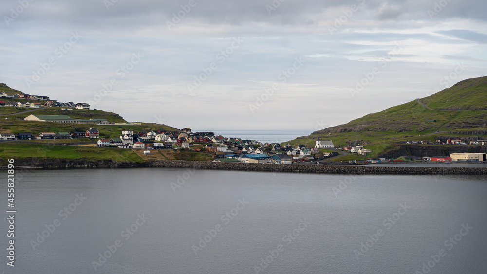 Beautiful aerial view of the town of Miovagur in the Faroe Islands, with its :churchs, grass roofs and colorful Houses in front of the ocean 