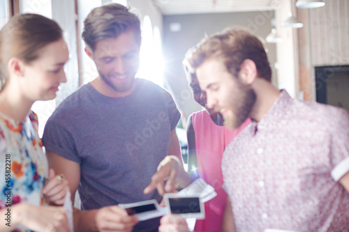 Smiling casual business people looking at instant photos