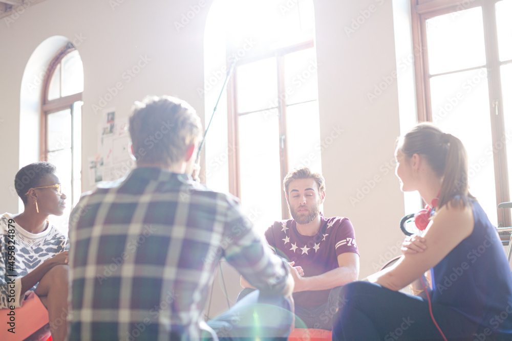 Casual business people meeting in circle in sunny office Casual business people meeting in circle in sunny office