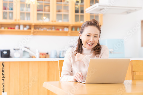 部屋でラップトップコンピューターを見るシニア女性