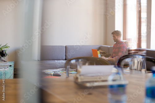 Creative businessman working at laptop in modern office