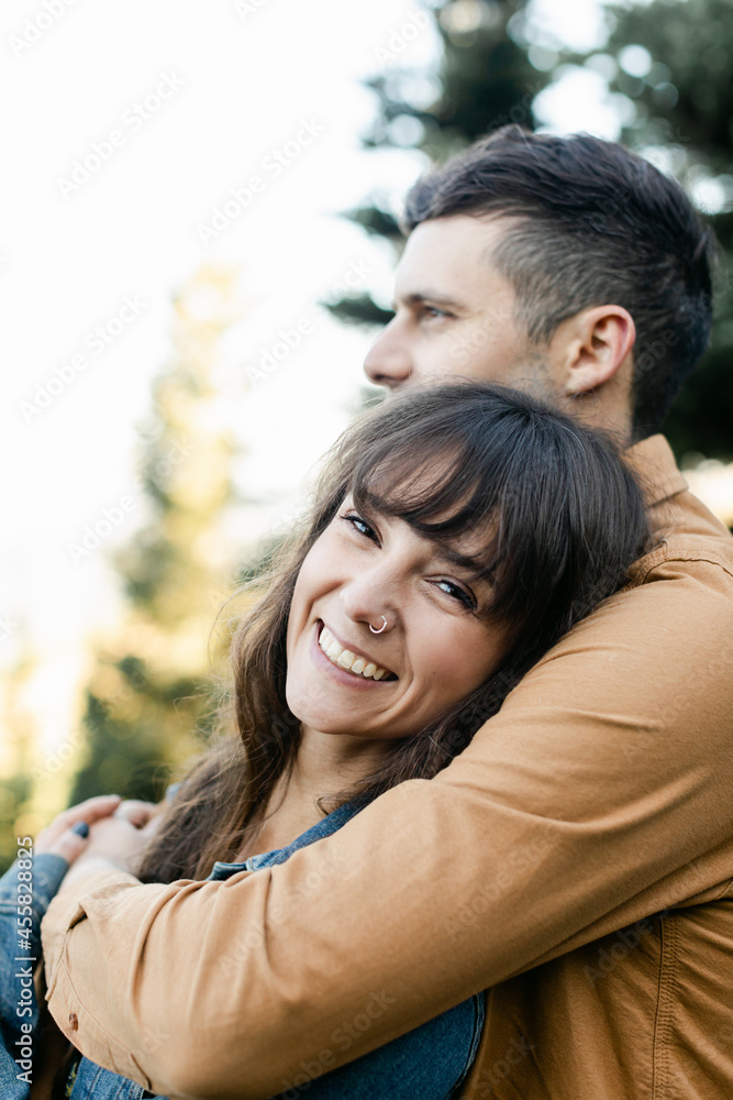 A Smiling, Beautiful Woman is Embraced by her Boyfriend A Smiling, Beautiful Woman is Embraced by her Boyfriend