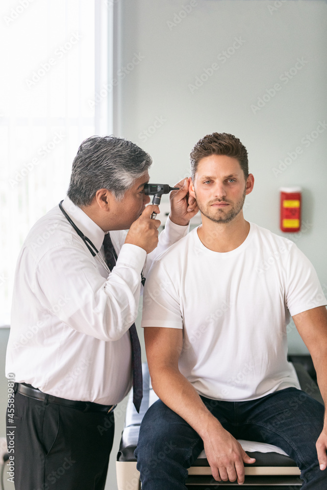 © Sean Locke/Stocksy - Exam: Doctor Uses Ophthalmoscope