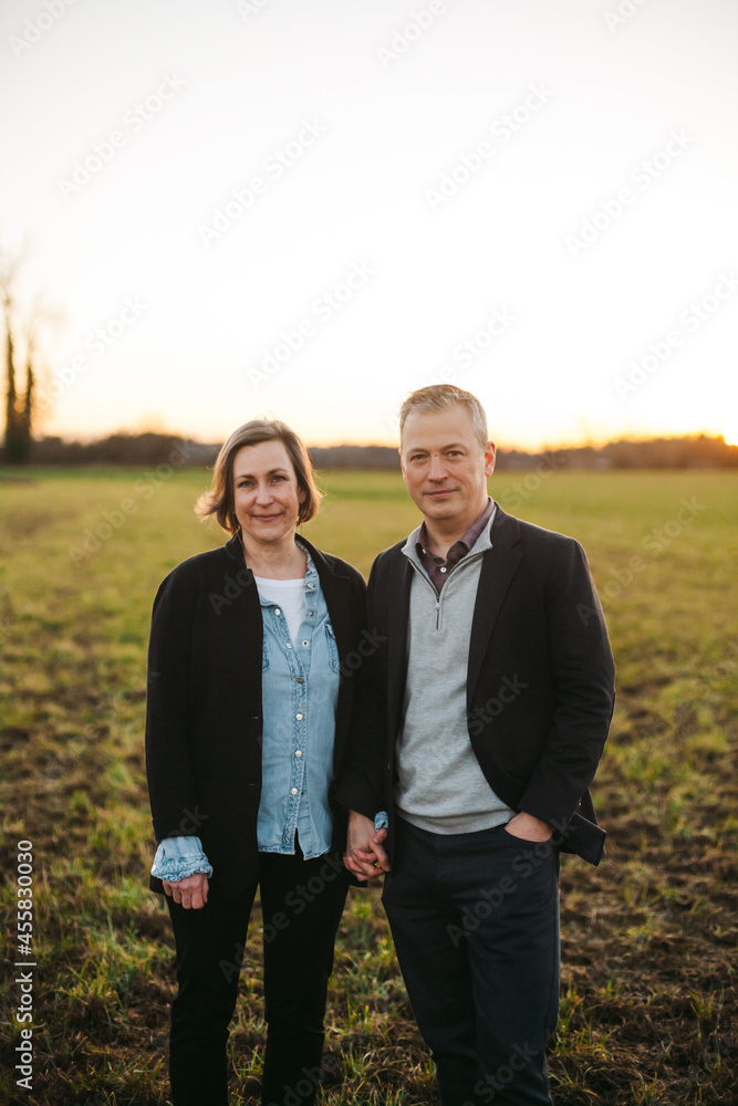 Happy middle age couple looking at camera outside. Happy middle age couple looking at camera outside.