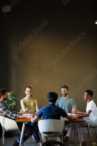 Casual business people working at tables in open office photo