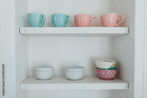 Kitchen cupboard with cups ans bowls photo