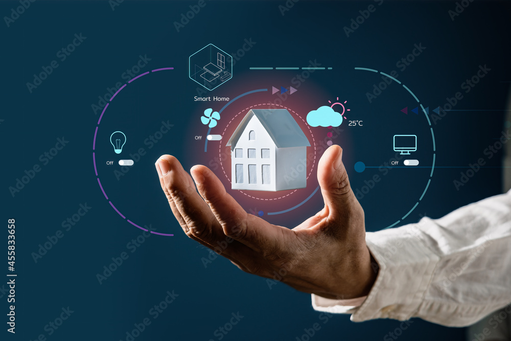 Businessman holding a house model with virtual screen of smart home automation application. Smart home controlling and Automation system technology of things Businessman holding a house model with virtual screen of smart home automation application. Smart home controlling and Automation system technology of things