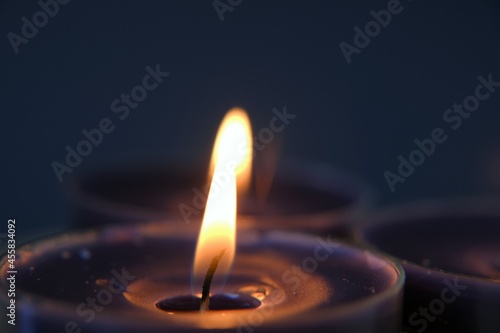 Burning candles.Candle flame.Set candles in the dark.Religion symbol. Candles background.Blue candles on dark blue background. 