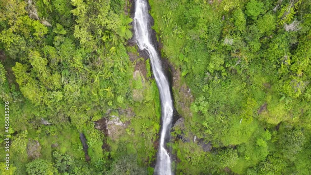 Epic drone shot of a high waterfall in a tropical forest in Java, Indonesia. Epic drone shot of a high waterfall in a tropical forest in Java, Indonesia.