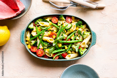 Pasta primavera with broccoli, green beans, corn, vegetables and cherry tomato