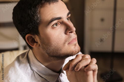 Young man praying at home i...