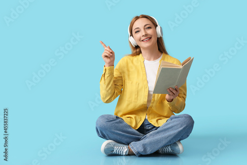 Mature woman with book poin...