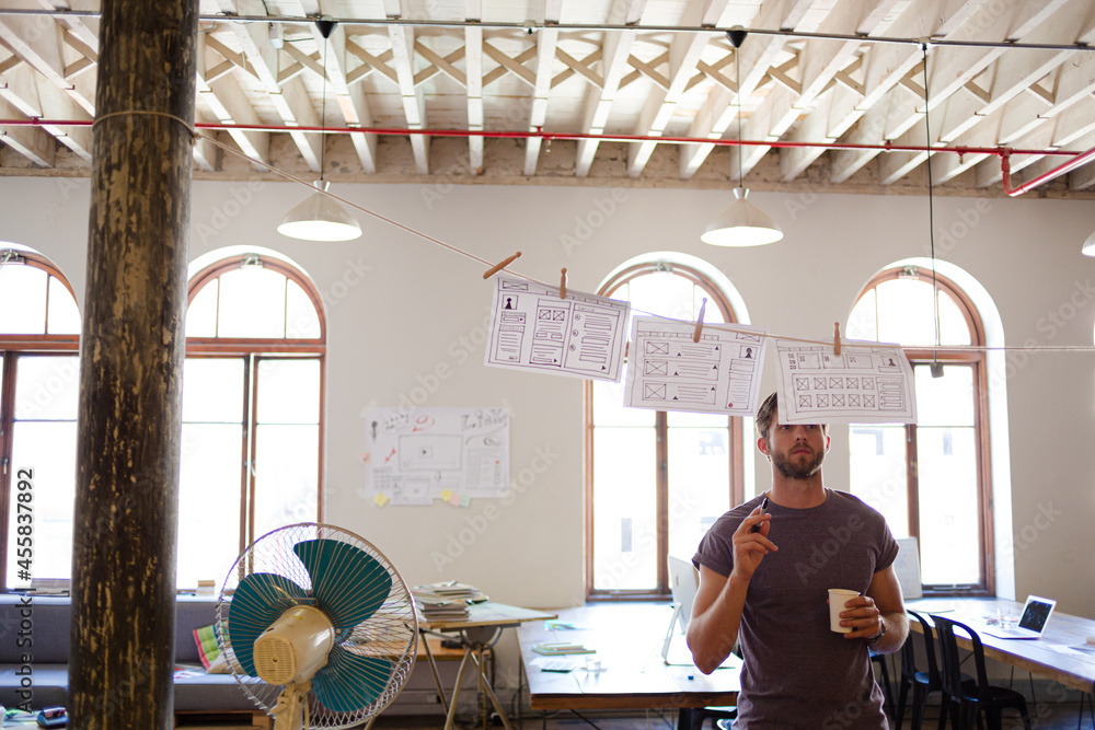 Creative businessman brainstorming with hanging diagrams Creative businessman brainstorming with hanging diagrams