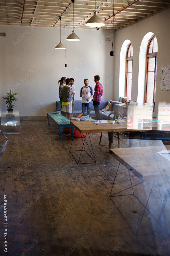 Creative business people talking in circle in office