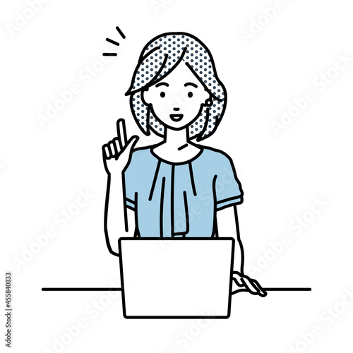 デスクで座ってPCを開いて何かひらめいたオフィスカジュアルの女性