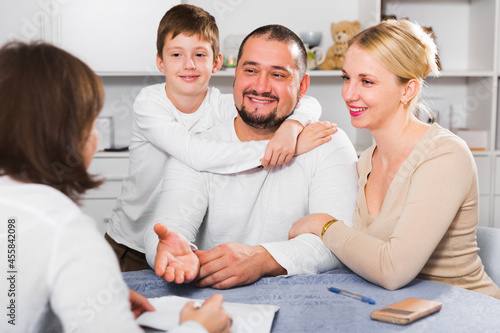 Happy young family of three meeting financial adviser for investment at home © JackF