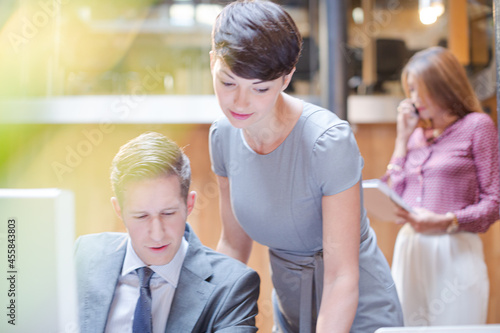 Businessman and businesswoman using computer in office