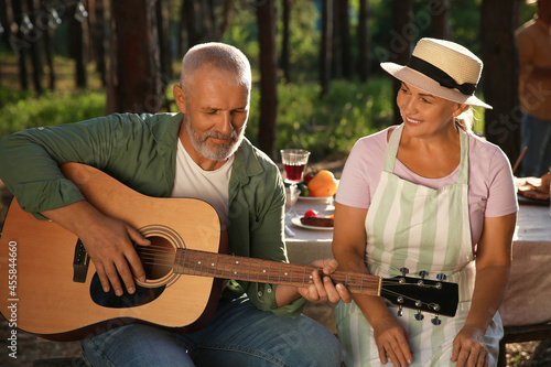 Mature man playing guitar a...