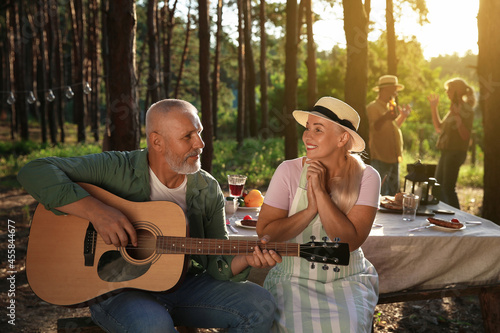 Mature man playing guitar a...