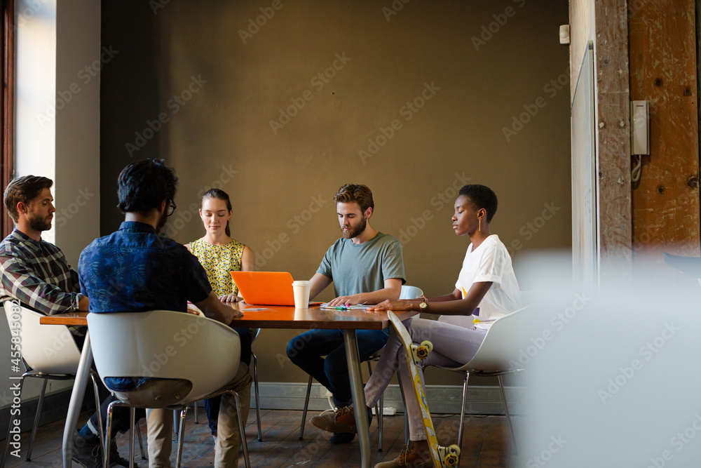 Casual business people meeting in circle in sunny office Casual business people meeting in circle in sunny office