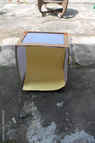 studio box containing yellow paper made of cardboard, white baking paper photo