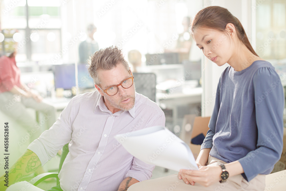 Obraz premium Business people reviewing paperwork at desk in office