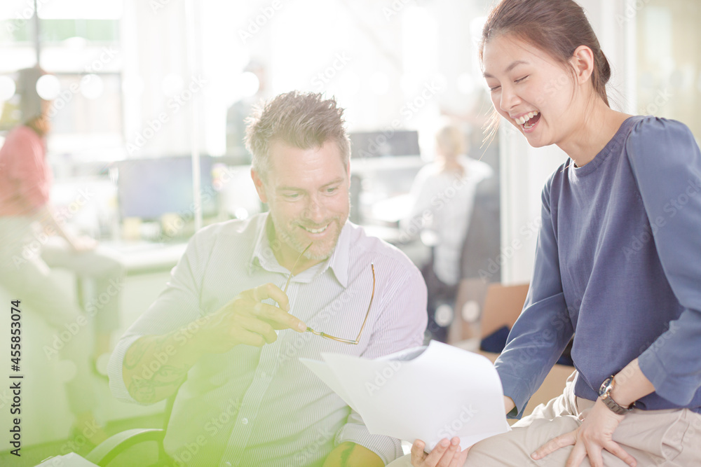 Business people reviewing paperwork at desk in office Business people reviewing paperwork at desk in office