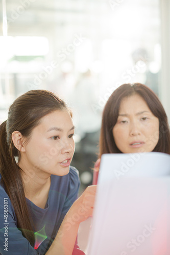 Businesswomen discussing paperwork in office