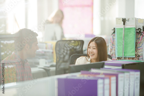 Fashion designers talking at desk in office