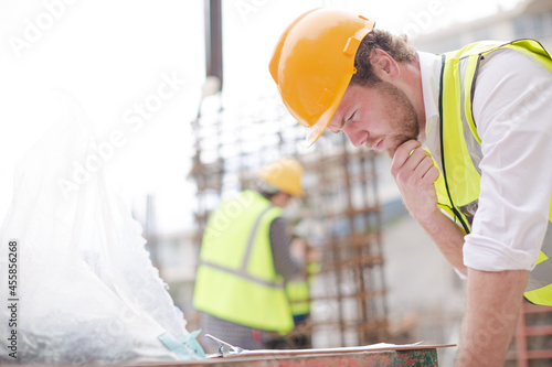 Foreman reading clipboard at construction site