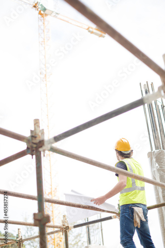 Engineer reviewing blueprints at high rise construction site