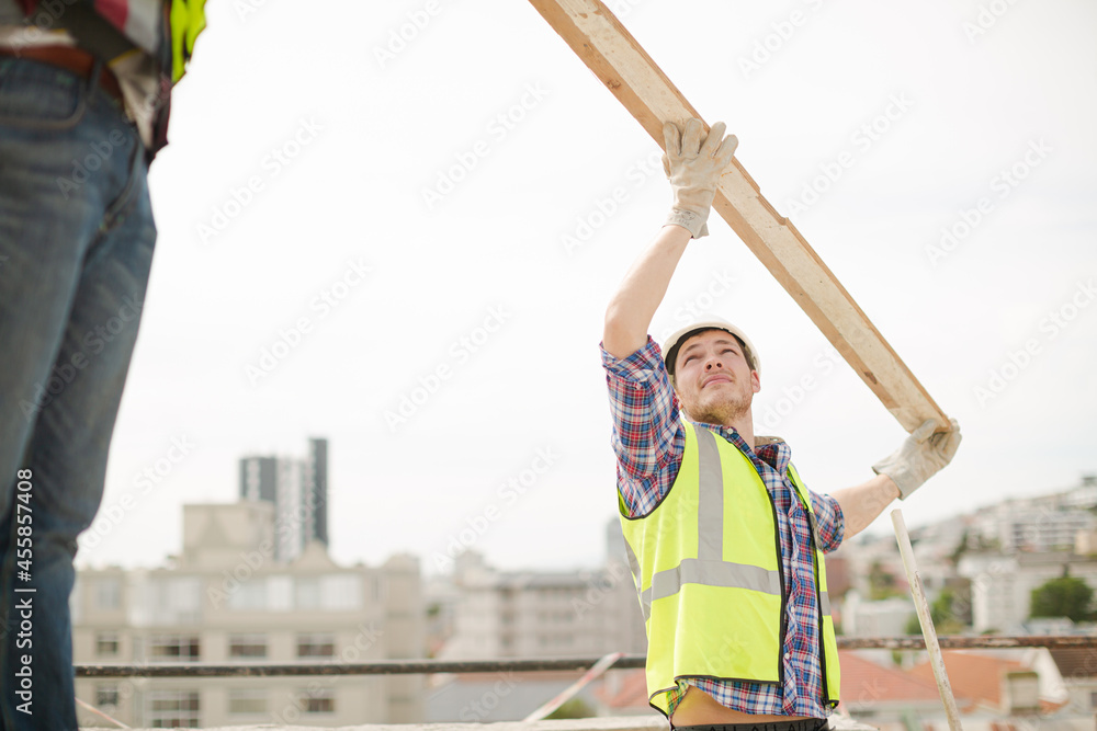 Construction workers lifting part at highrise construction site Construction workers lifting part at highrise construction site