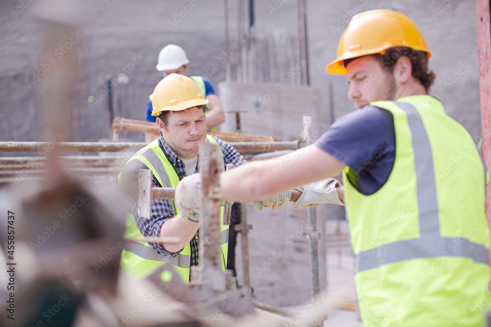 Constructor workers assembling rebar structure at construction site Constructor workers assembling rebar structure at construction site