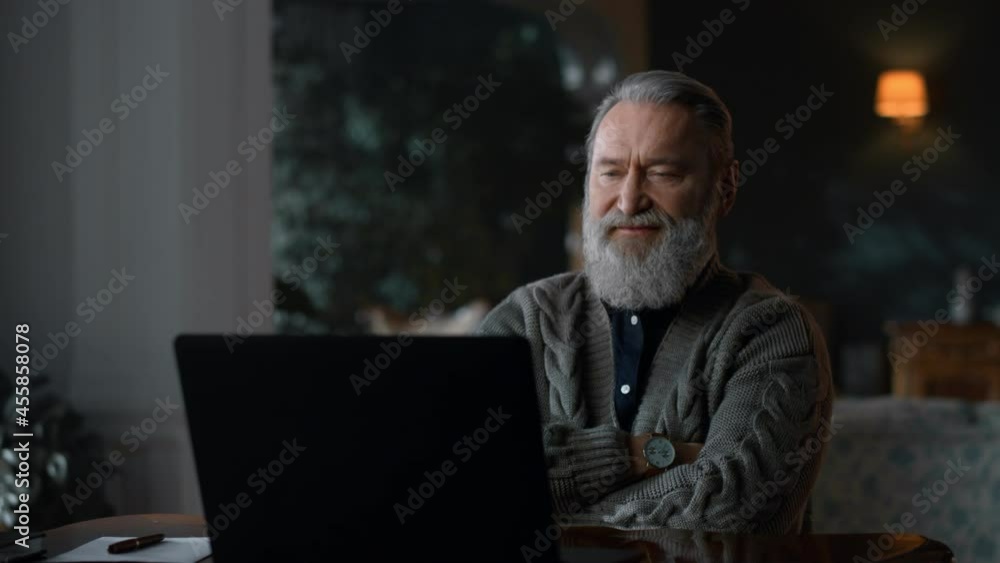 Senior man calling video online at laptop computer . Old man using computer Senior man calling video online at laptop computer . Old man using computer