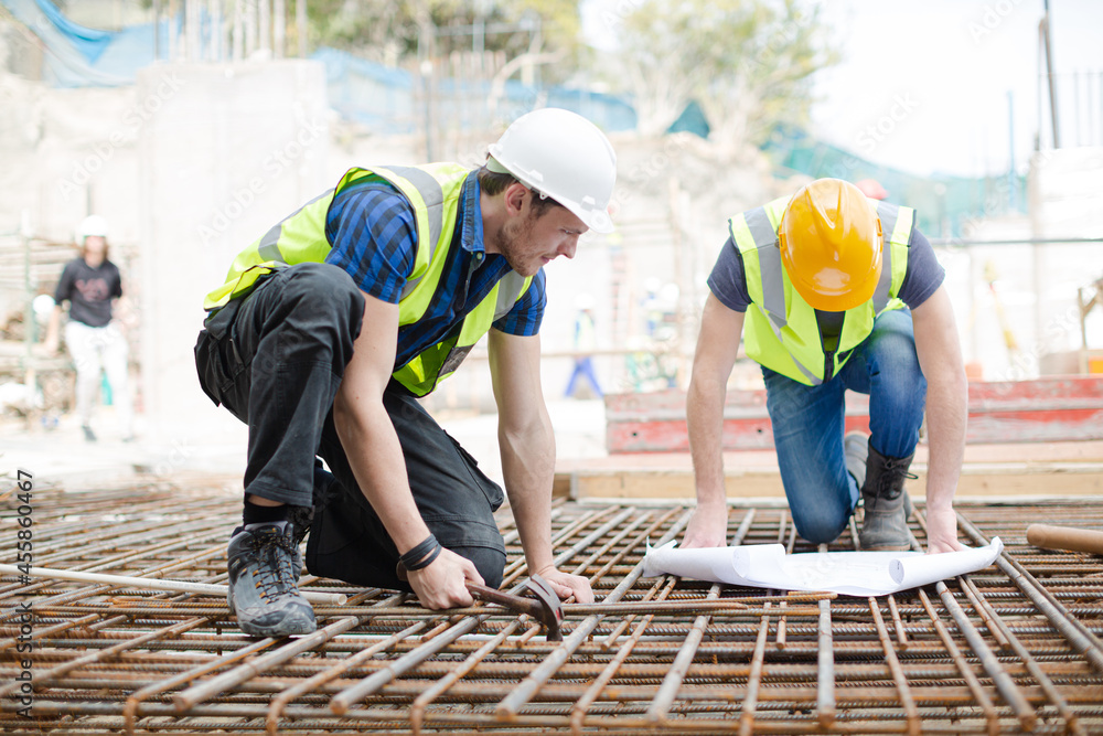 Photography Construction workers engineer reviewing blueprints at construction site