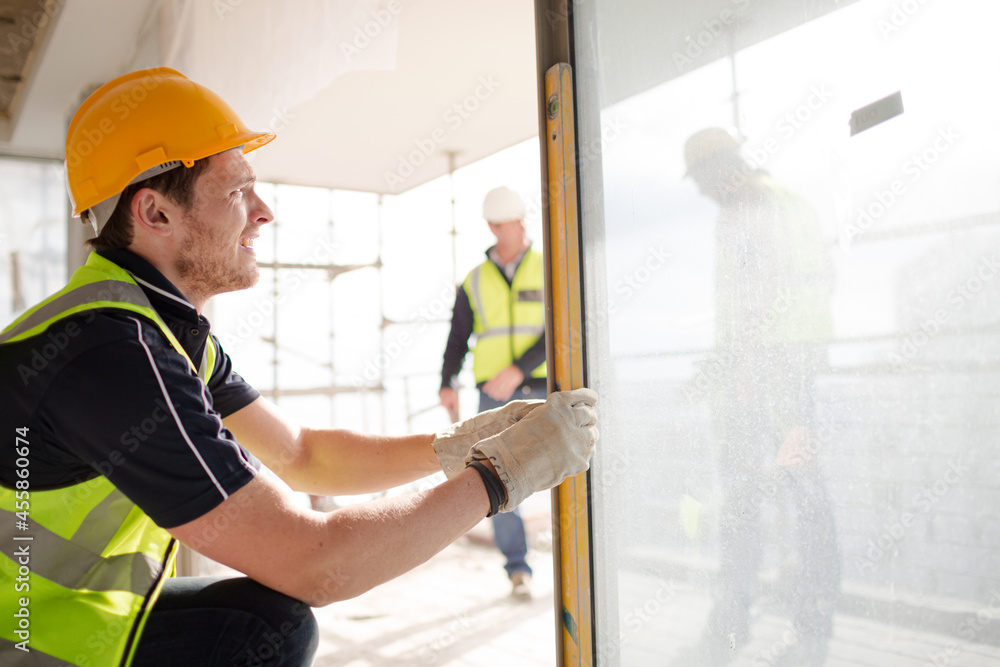 © KOTO - Construction worker measuring window at construction site