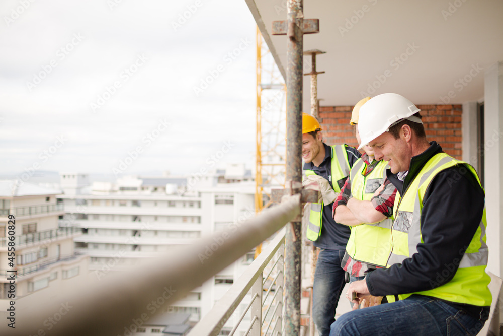 Construction workers talking at highrise construction site Construction workers talking at highrise construction site