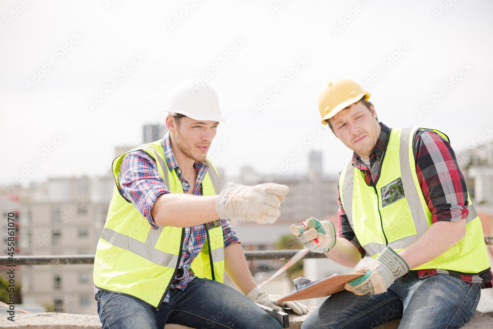 Construction worker engineer clipboard pointing at highrise construction site Construction worker engineer clipboard pointing at highrise construction site